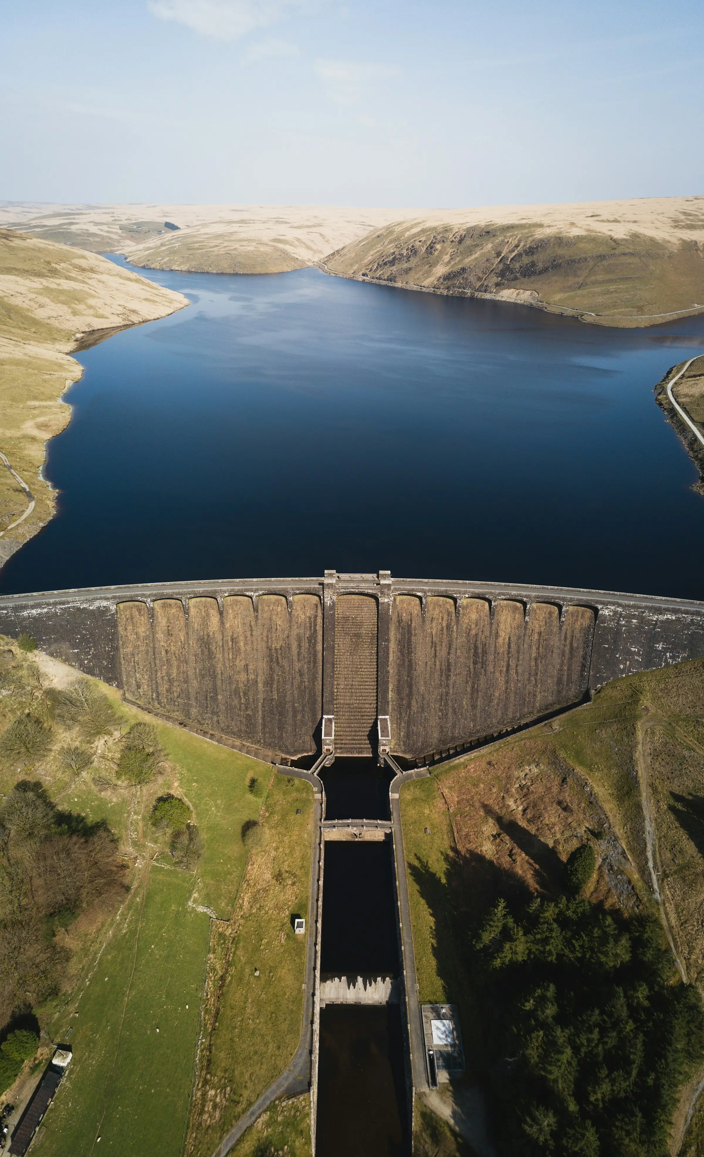 Aerial view of a dam wall, reservoir and spillway channel