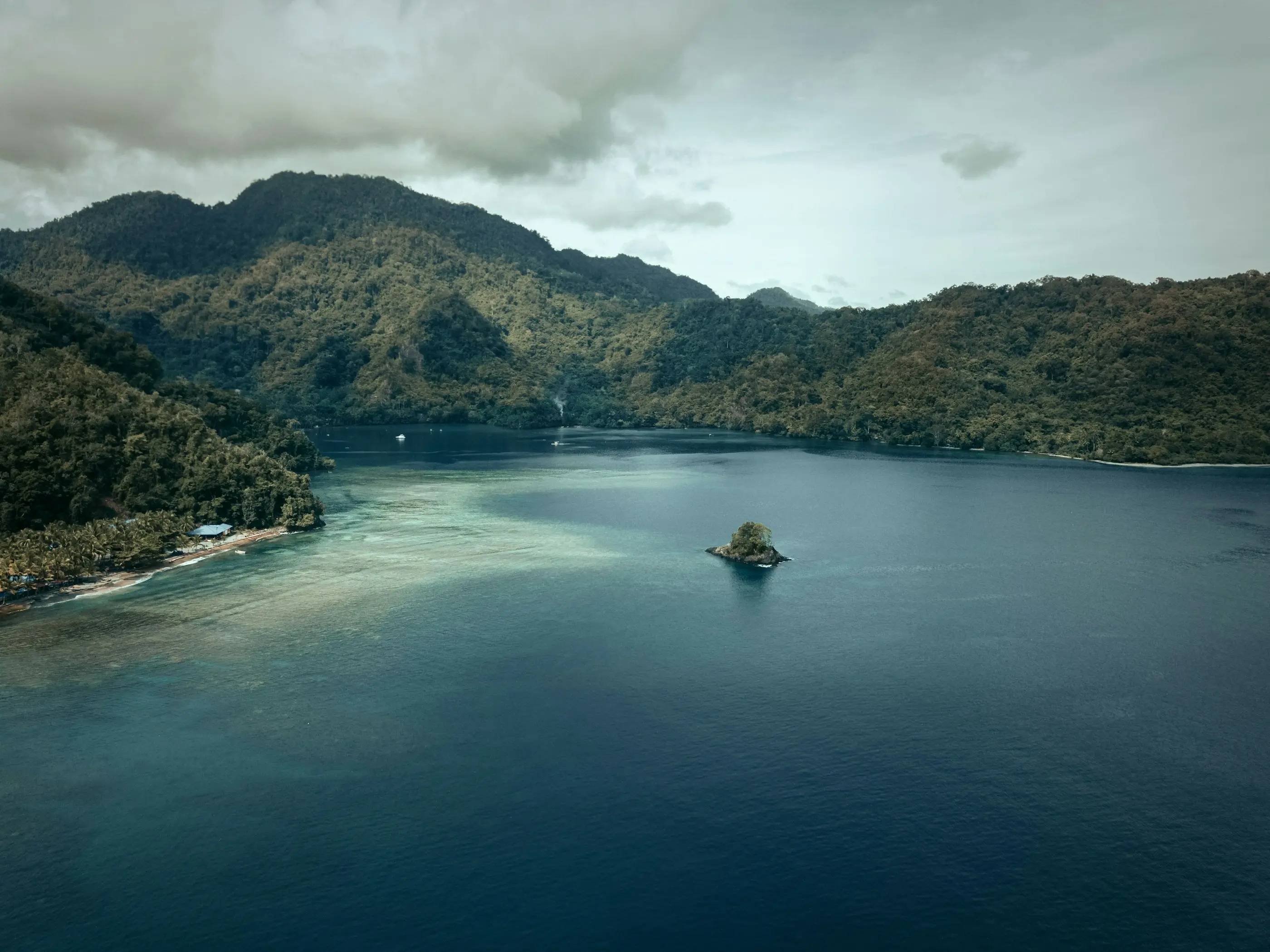 Tropical coastal bay with a village and forested ridges