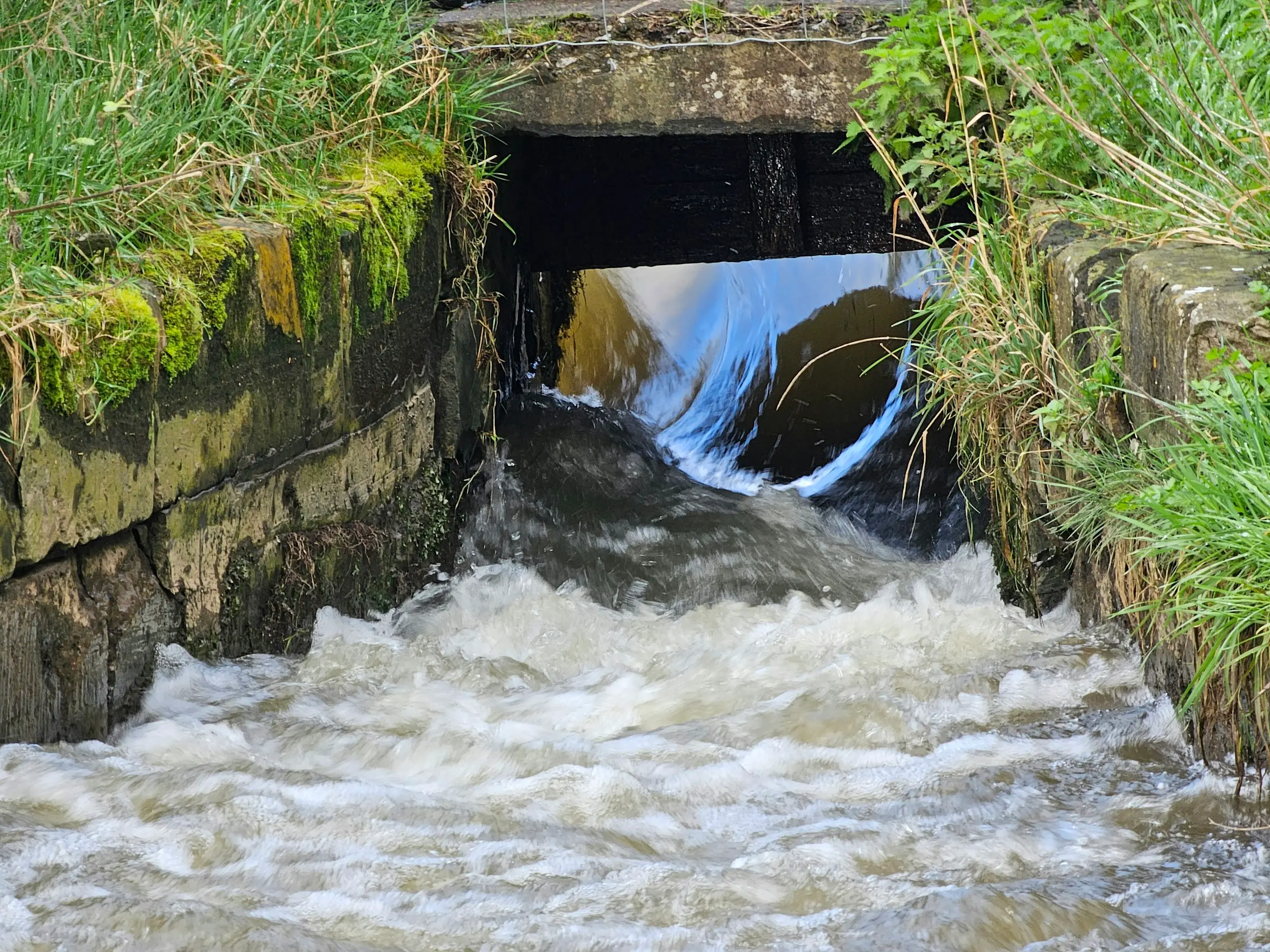 Water discharging from a stone culvert outlet